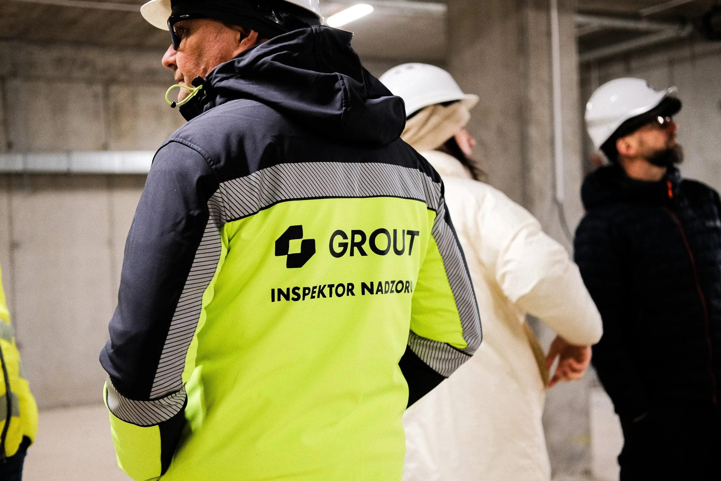Zespół Grout podczas odbioru na budowie. Na kurtce napis: Grout, inspektor nadzoru.
